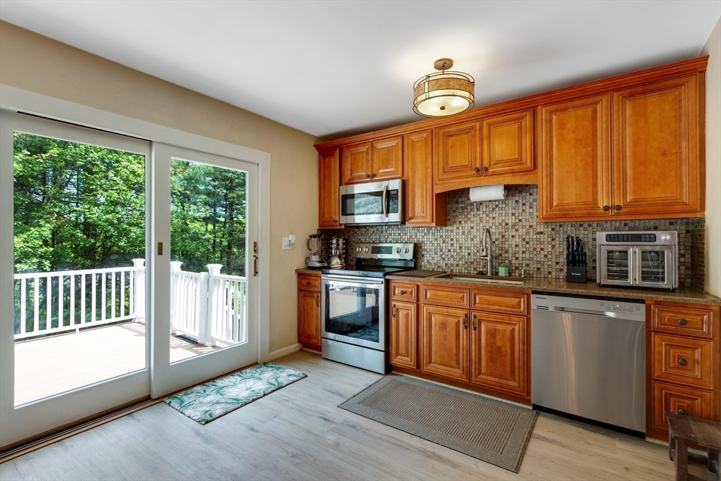 15 Conestoga Road Lexington, MA 02421 - Photo 6 of 31 a kitchen with granite countertop wooden cabinets a stove a sink and stainless steel appliances