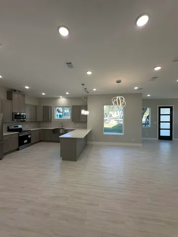 a view of kitchen with kitchen island a sink stainless steel appliances and cabinets