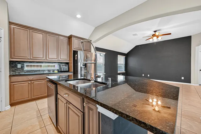a kitchen with stainless steel appliances granite countertop a sink and a stove