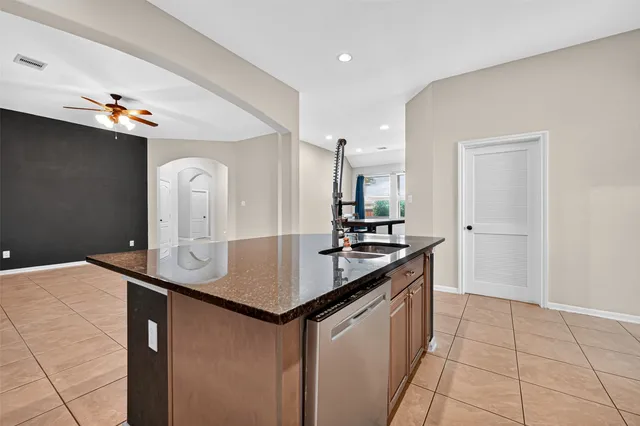 a kitchen with stainless steel appliances granite countertop a sink and a refrigerator