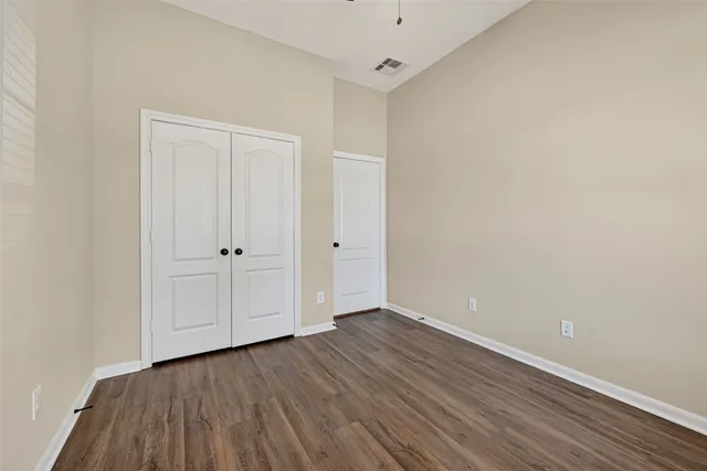 a view of an empty room with wooden floor