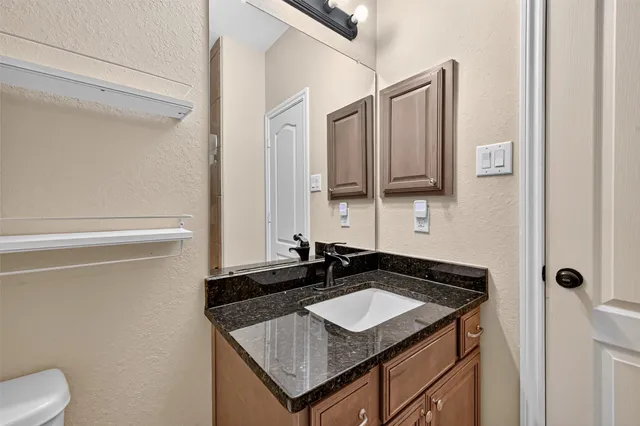 a bathroom with a granite countertop sink and a mirror