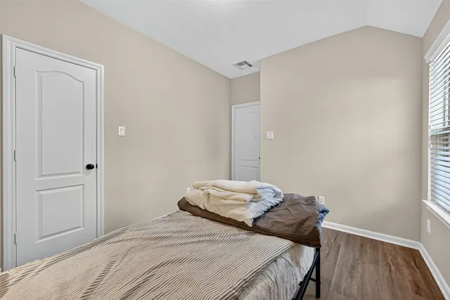 a bedroom with a bed and wooden floor
