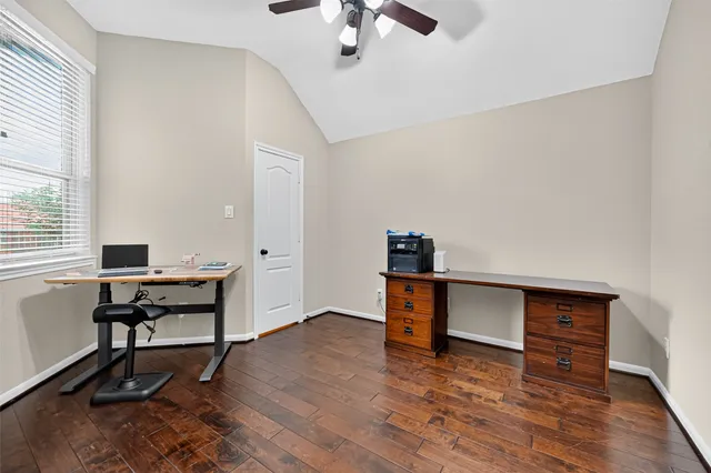 a view of a workspace with furniture and a window