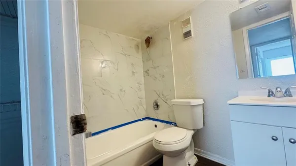 a bathroom with a granite countertop toilet a sink and a mirror