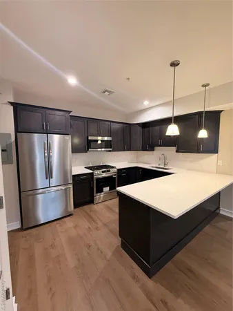 a kitchen with kitchen island a sink stainless steel appliances and cabinets
