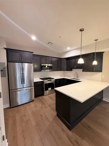 a kitchen with kitchen island a sink stainless steel appliances and cabinets