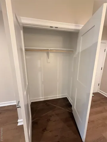 a view of walk in closet with wooden floor