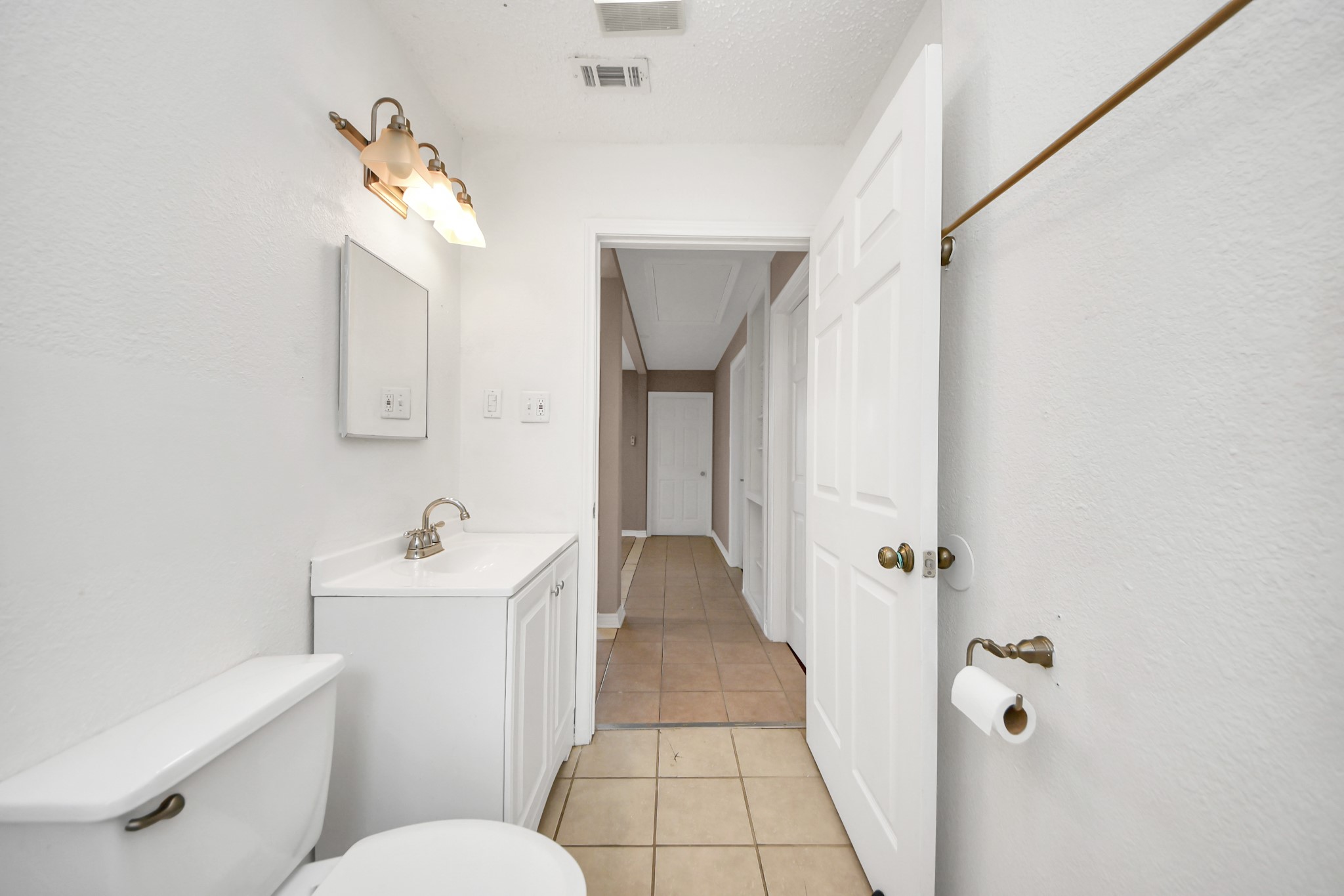 5202 Pensdale Street Houston, TX 77033 - Photo 11 of 32 a bathroom with a toilet sink and mirror