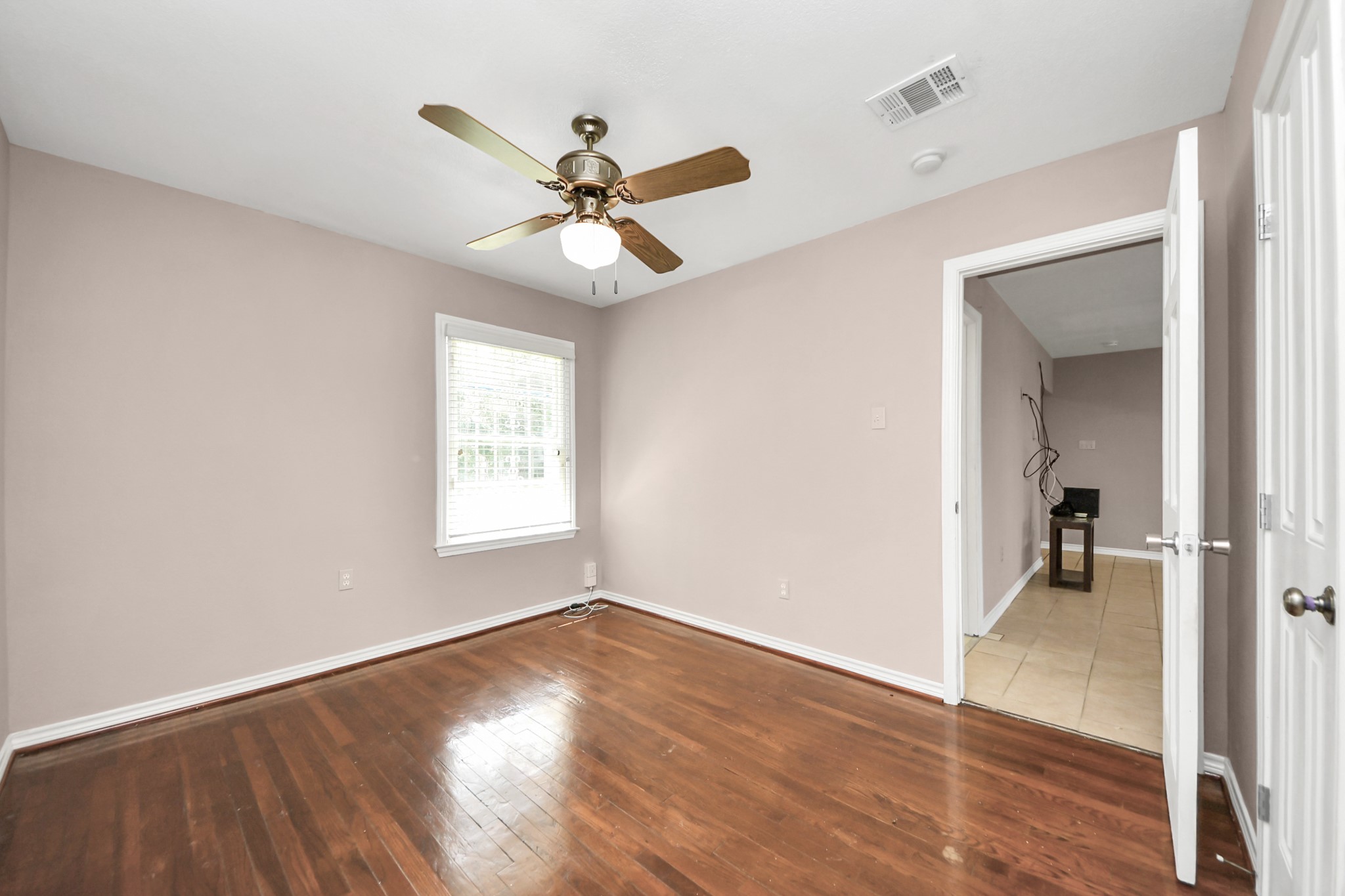 5202 Pensdale Street Houston, TX 77033 - Photo 15 of 32 an empty room with wooden floor fan and windows