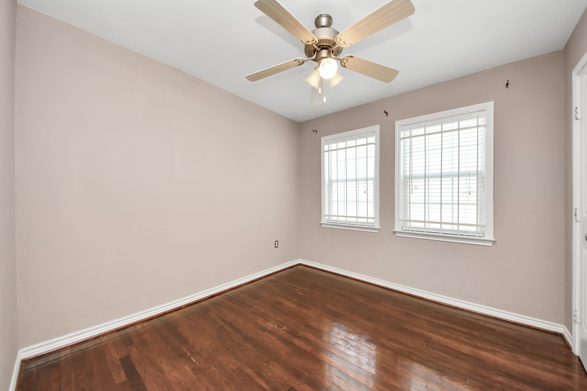 5202 Pensdale Street Houston, TX 77033 - Photo 16 of 32 an empty room with wooden floor and windows