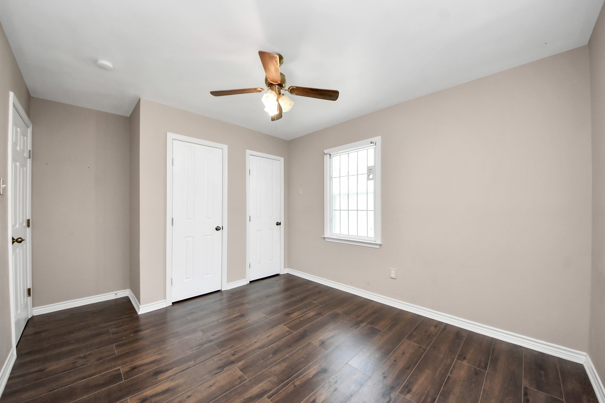 5202 Pensdale Street Houston, TX 77033 - Photo 18 of 32 an empty room with wooden floor and windows