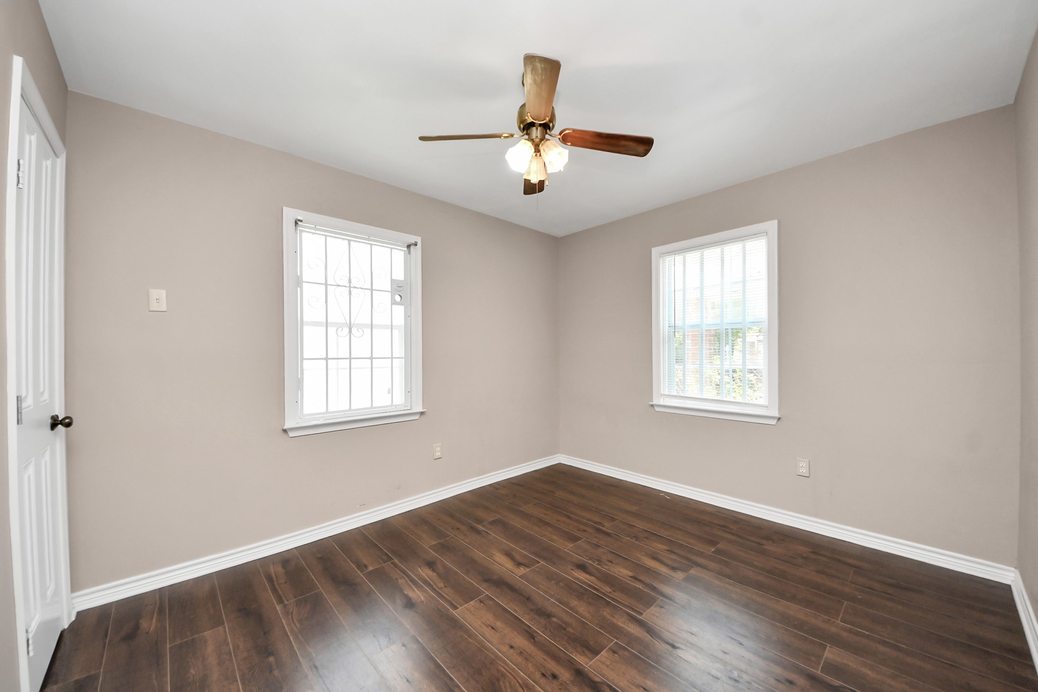 5202 Pensdale Street Houston, TX 77033 - Photo 19 of 32 a view of an empty room with wooden floor and a window