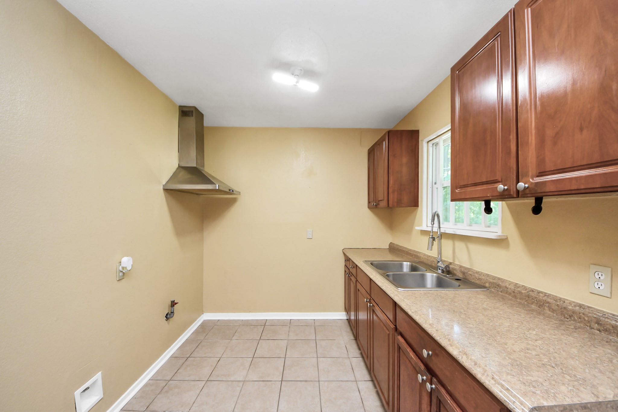 5202 Pensdale Street Houston, TX 77033 - Photo 20 of 32 a kitchen with a sink and a refrigerator