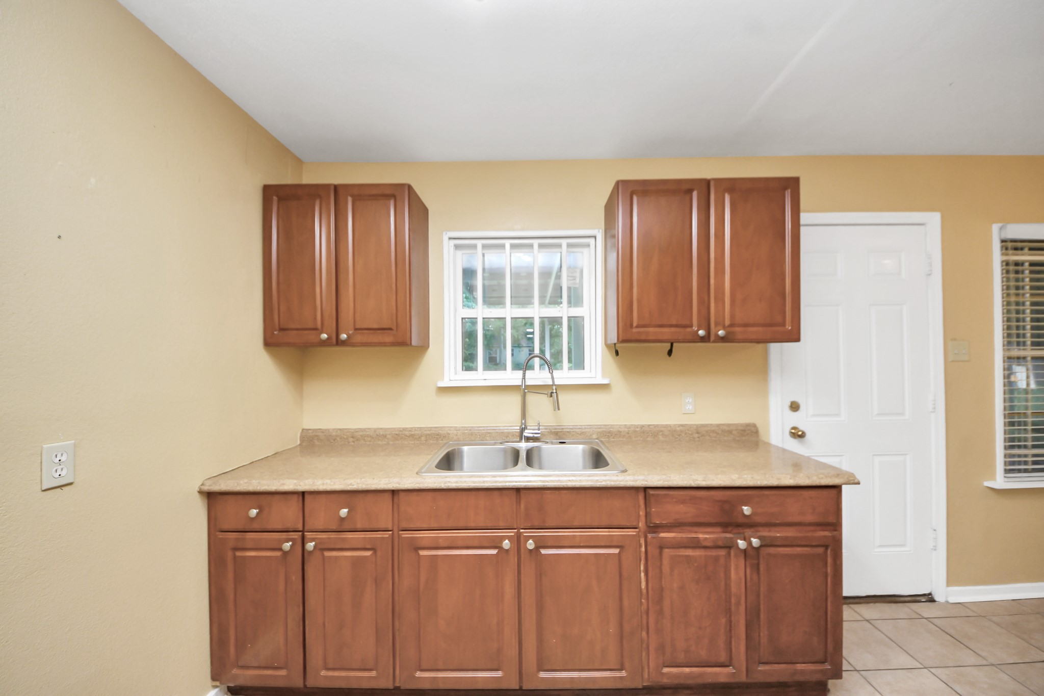 5202 Pensdale Street Houston, TX 77033 - Photo 24 of 32 a kitchen with stainless steel appliances granite countertop a sink and dishwasher with wooden cabinets