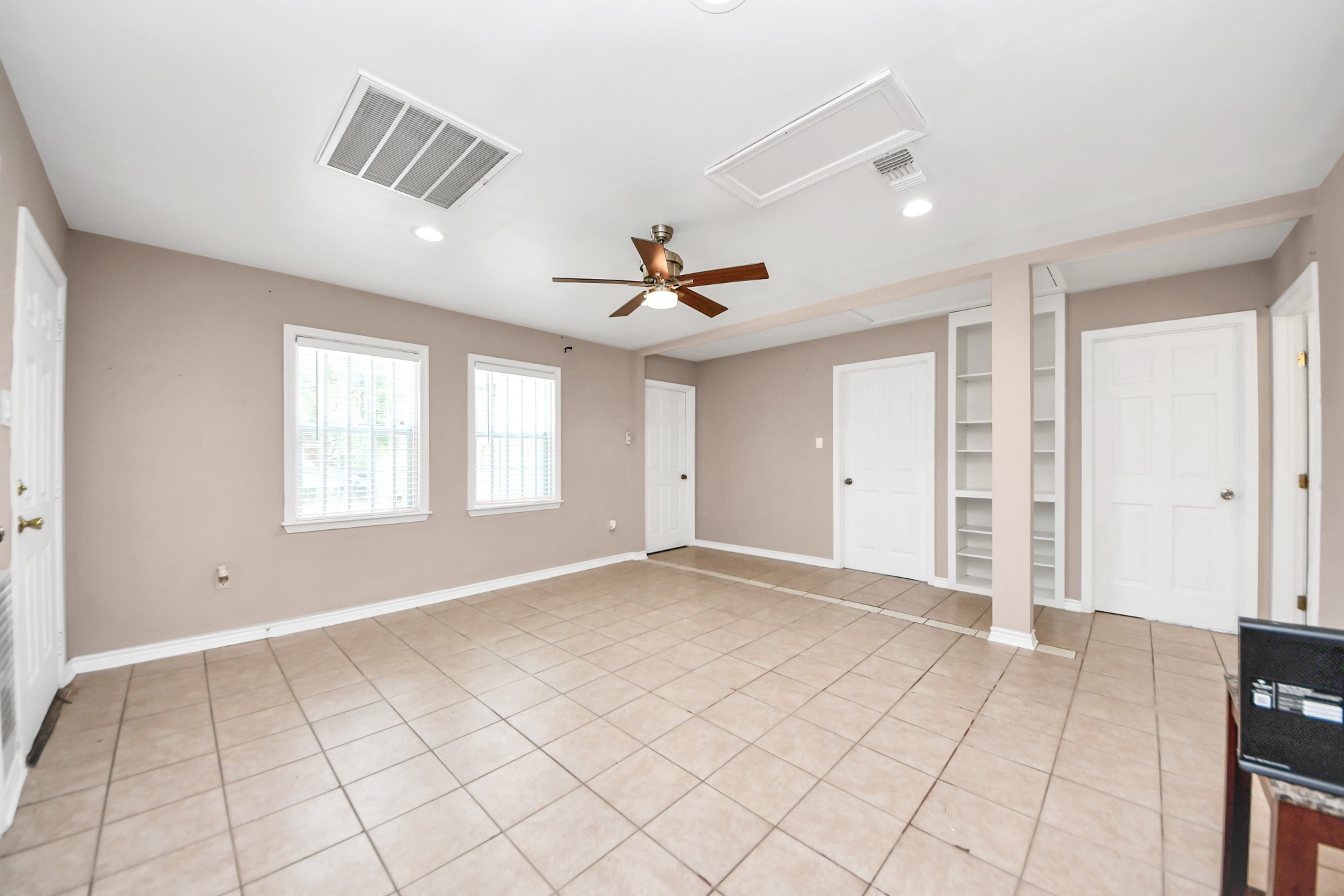 5202 Pensdale Street Houston, TX 77033 - Photo 8 of 32 an empty room with windows and ceiling fan