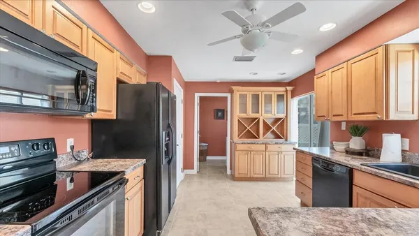 a kitchen with stainless steel appliances granite countertop a refrigerator stove and sink