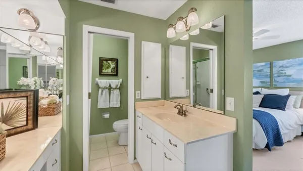 a spacious bathroom with a granite countertop sink a toilet a mirror and shower