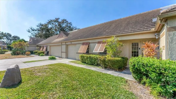 a front view of a house with a yard and potted plants