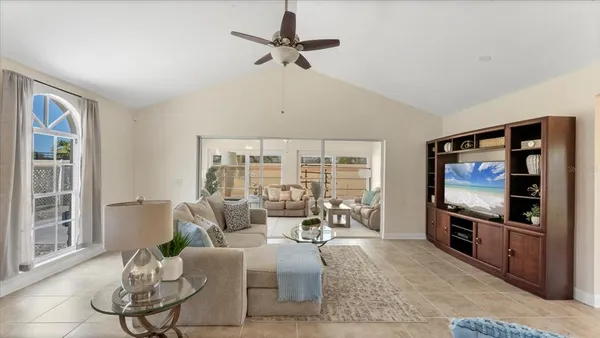 a living room with furniture a flat screen tv and a large window