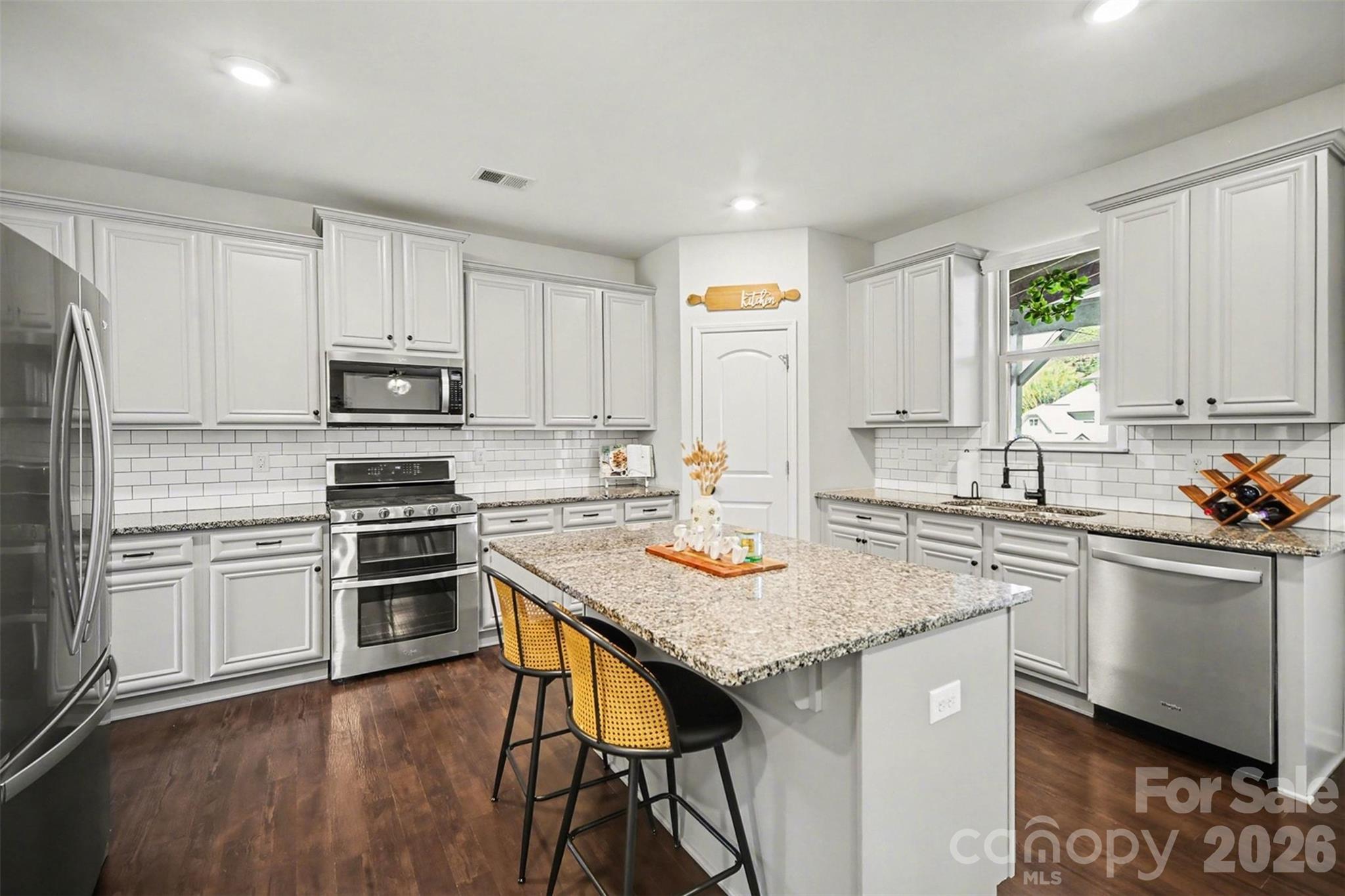 514 Tack Lane Midland, NC 28107 - Photo 11 of 48 a kitchen with stainless steel appliances granite countertop a stove a sink dishwasher a refrigerator and white cabinets with wooden floor