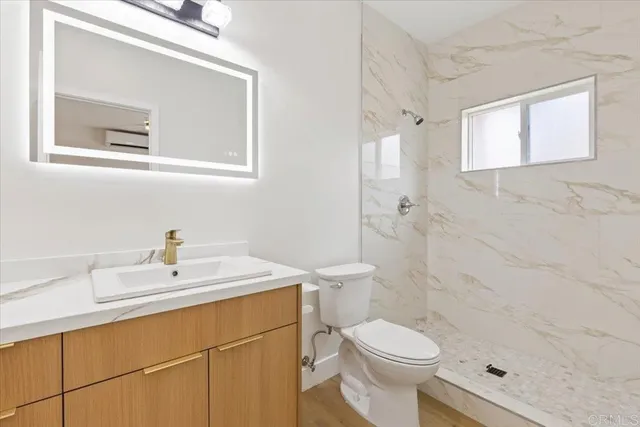 a bathroom with a sink a toilet and shower