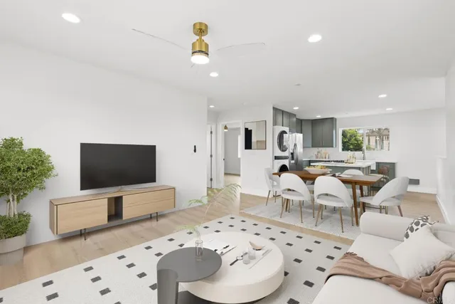 a living room with furniture a flat screen tv and a potted plant