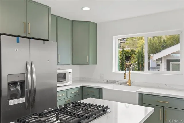 a kitchen with stainless steel appliances granite countertop a sink stove and refrigerator