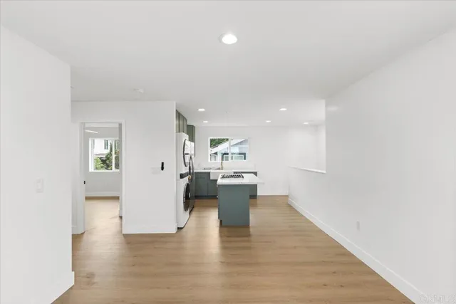a view of a kitchen with wooden floor and windows