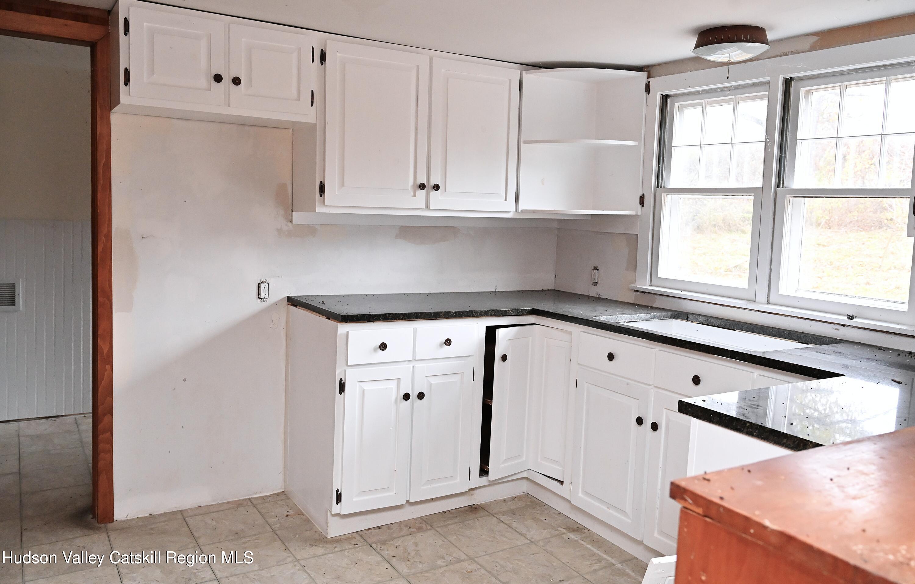 163 County Rte 14 Hudson, NY 12534 - Photo 14 of 49 a kitchen with granite countertop white cabinets and white appliances