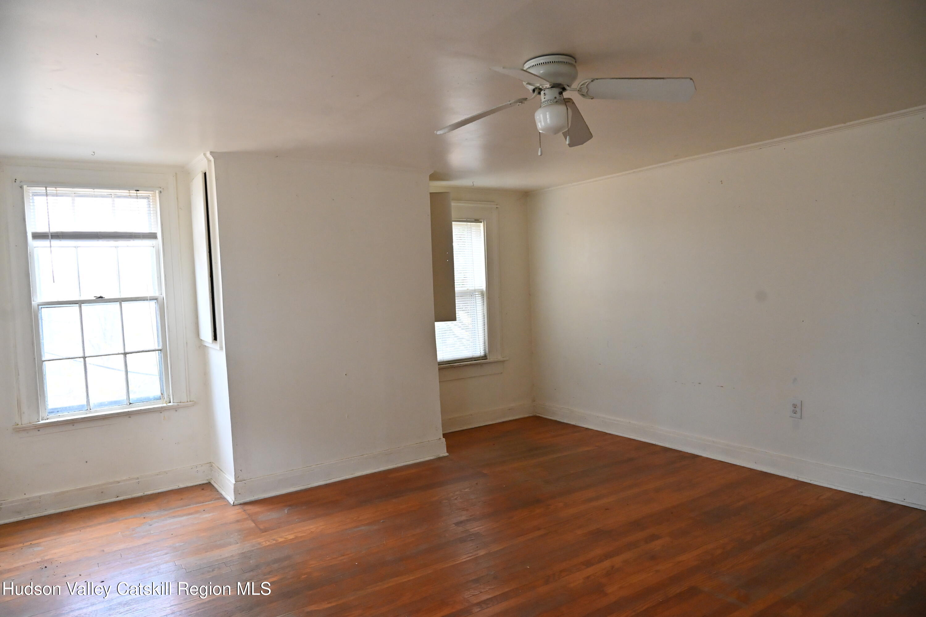 163 County Rte 14 Hudson, NY 12534 - Photo 28 of 49 an empty room with wooden floor chandelier fan and windows