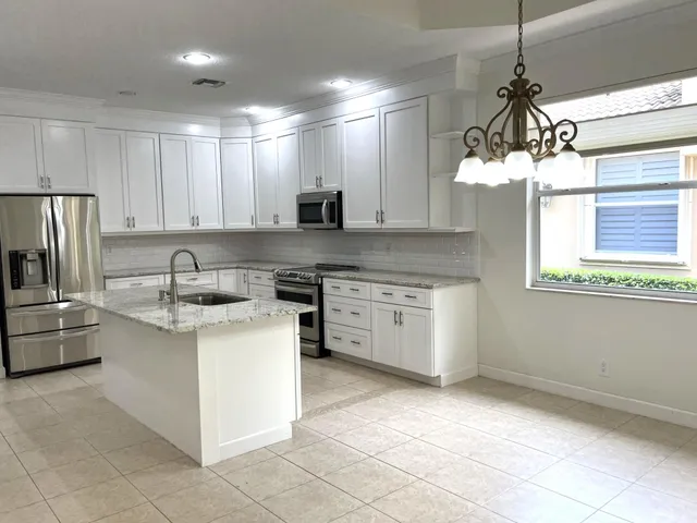a kitchen with a stove a sink a refrigerator and window