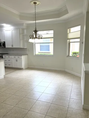 a view of kitchen with granite countertop cabinets and window