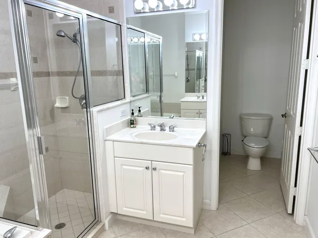 a bathroom with a double vanity sink toilet and shower