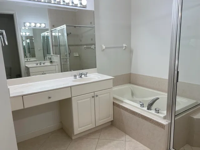 a bathroom with a sink double vanity mirror and bathtub