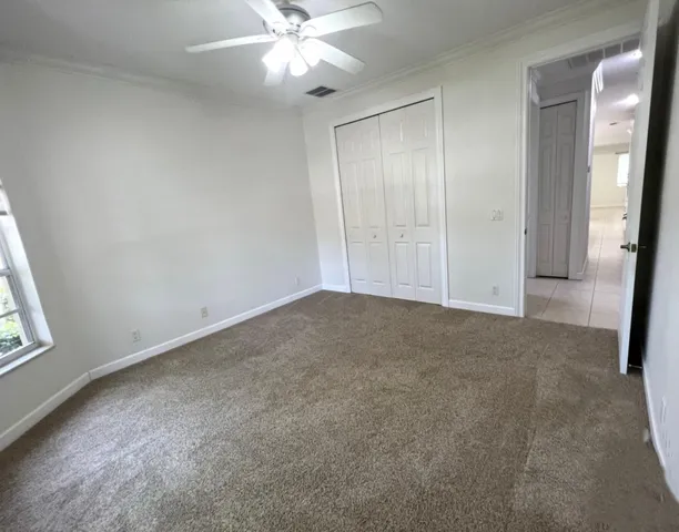 an empty room with windows and fan