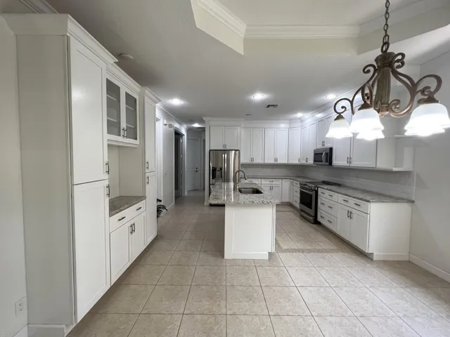 a large kitchen with white cabinets and stainless steel appliances