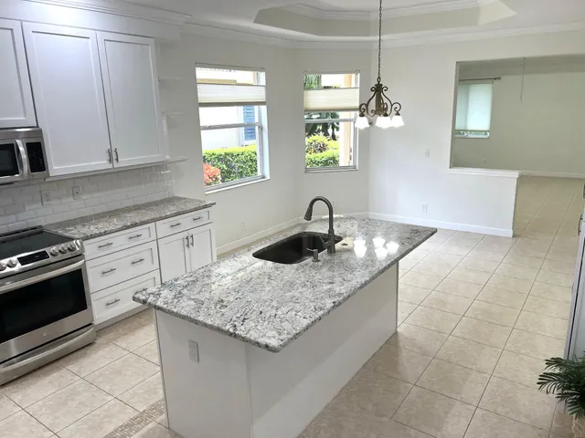 a kitchen with granite countertop a sink a stove and cabinets