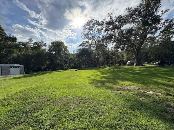 a backyard of a house with lots of green space and fountain