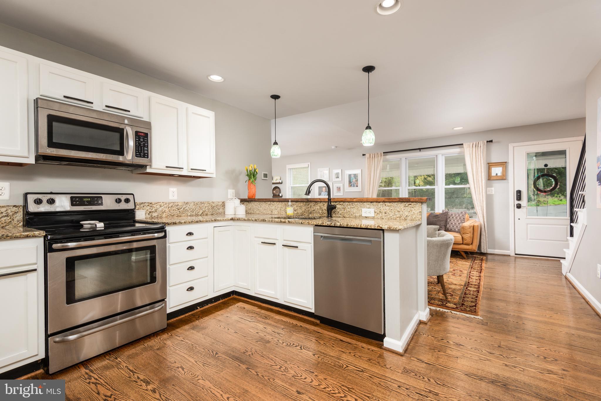 134 Cresston Road Arnold, MD 21012 - Photo 26 of 35 a kitchen with stainless steel appliances white cabinets a sink a stove a microwave and wooden floors