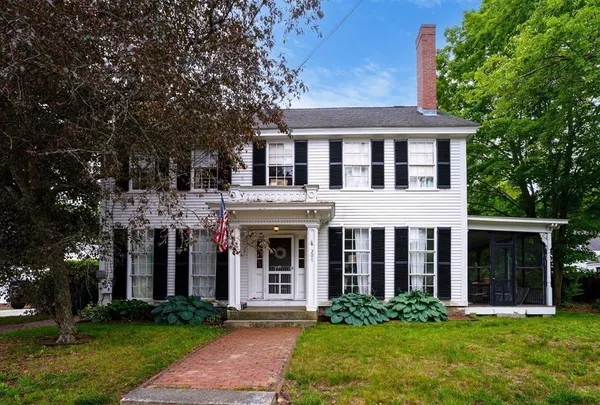 front view of a brick house with a yard