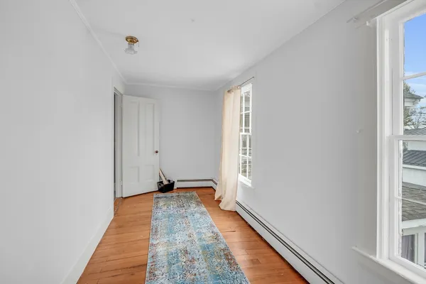 a view of a bedroom with wooden floor