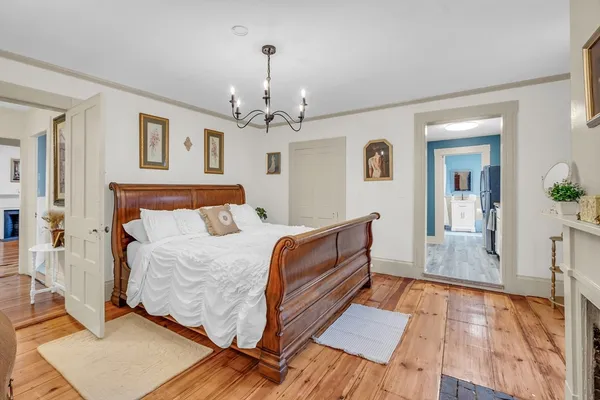 a spacious bedroom with a bed and wooden floor