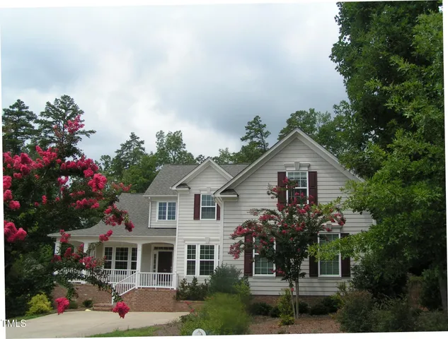 a view of a house with a yard and potted plants