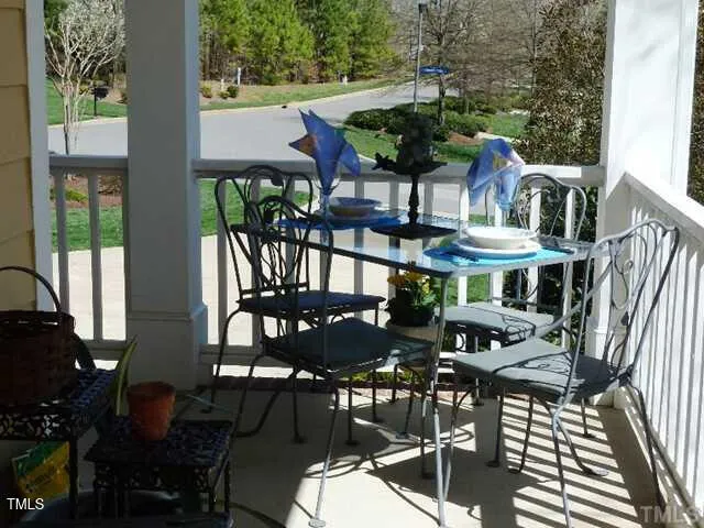 a view of a patio with table and chairs with wooden floor and fence