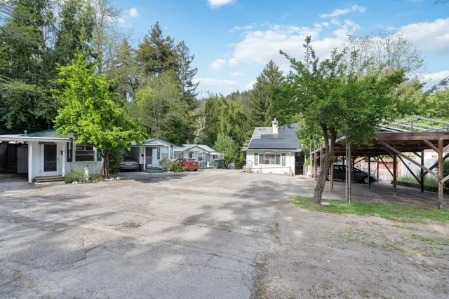 a white house that has a tree in front of it