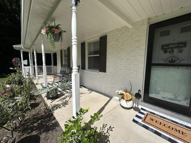 9191 Red Road Kempton, PA 19529 - Photo 7 of 25 An inviting covered front porch stands out against painted brick siding and classic shutters.