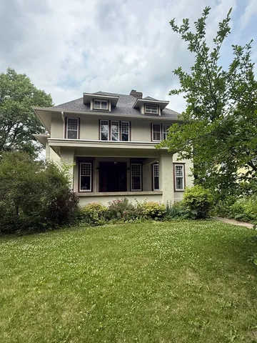 a front view of a house with a garden