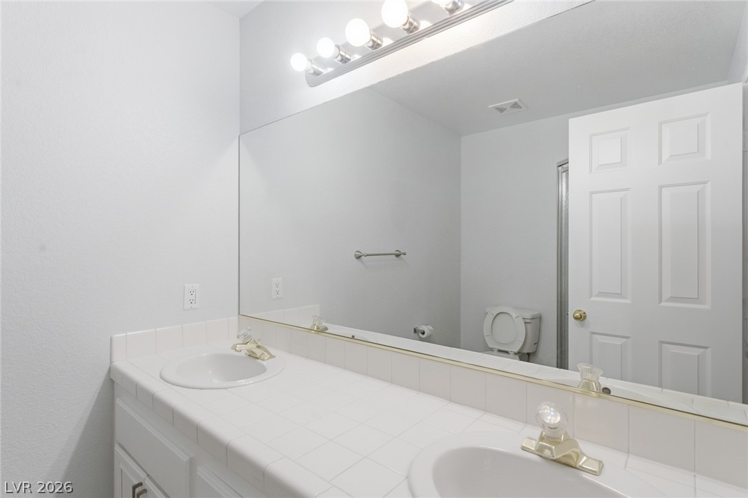 5449 Bugle Way, Unit 104 Las Vegas, NV 89108 - Photo 25 of 33 This bright bathroom offers ample counter space and a spacious mirror for daily routines.