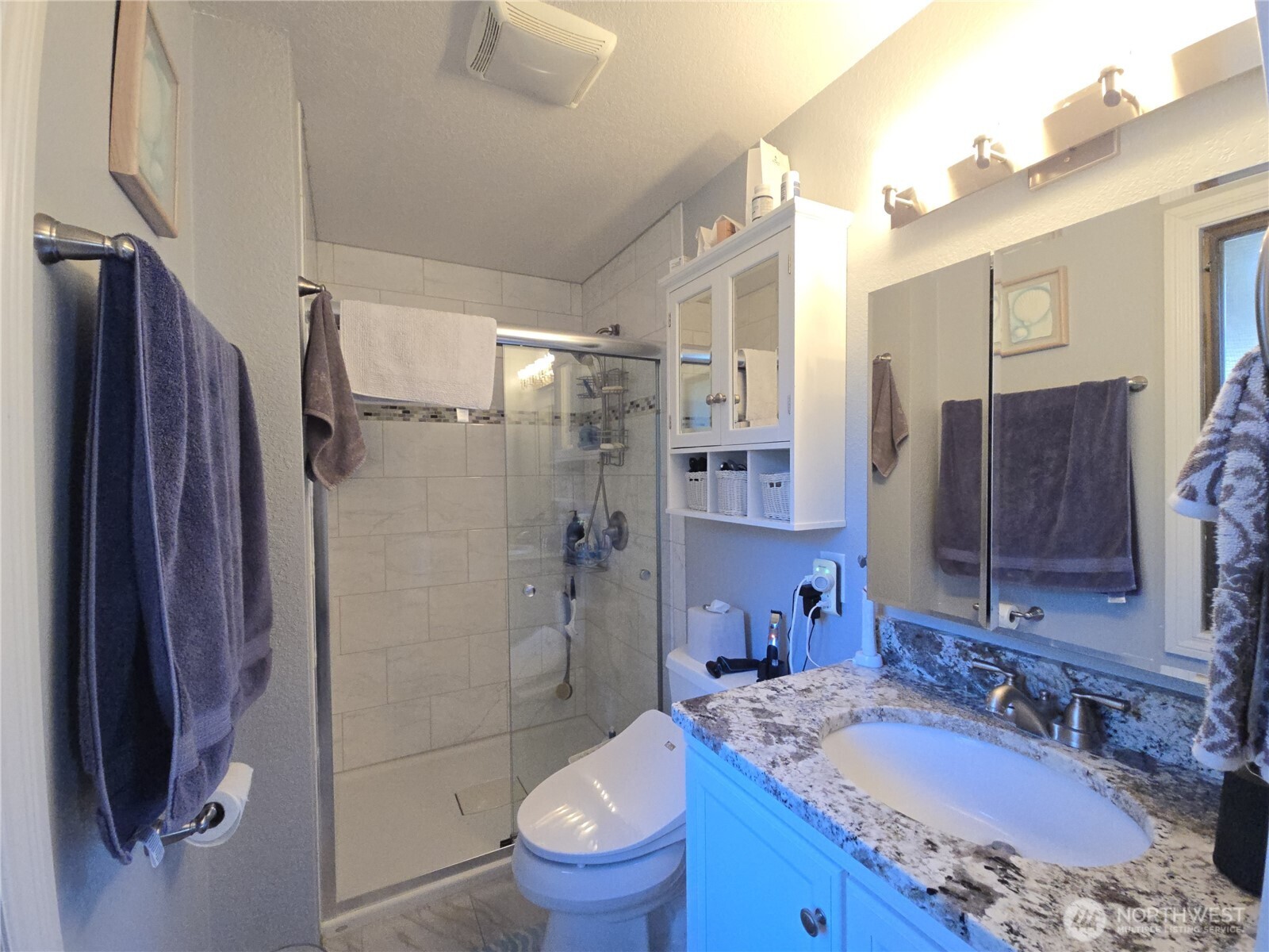 296 Taylor Boulevard Sequim, WA 98382 - Photo 17 of 29 a bathroom with a granite countertop sink toilet and shower